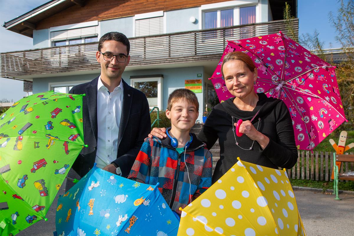 Fröhliche Kinderschirme für die regnerische Jahreszeit: Michael Ornig (doppler Schirme), Leon und Isabella Müller (SOS Kinderdorf Seekirchen)