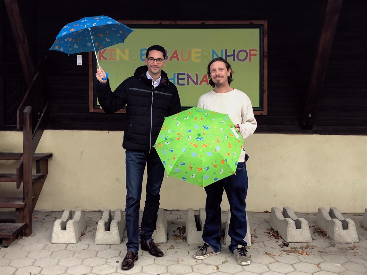 Fröhliche Kinderschirme für die regnerische Jahreszeit: Michael Ornig (doppler Schirme) und Stefan Pfeiller (Kinderbauernhof Eschenau)